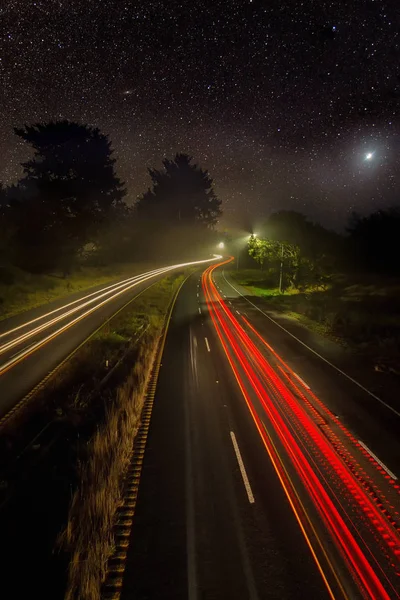 Immagine notturna di automobili su un'autostrada sotto le stelle — Foto Stock
