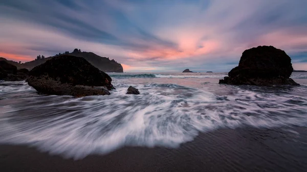 Rotsachtig strand landschap bij zonsondergang — Stockfoto