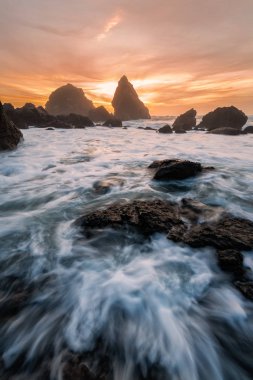 Akşam günbatımında tropikal bir kayalık plaj