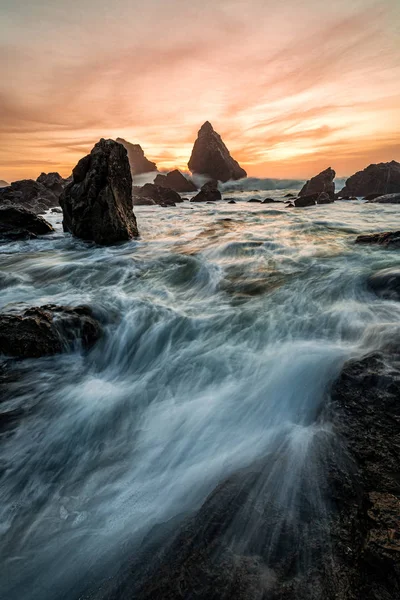 Avond zonsondergang op een tropische rotsachtige strand — Stockfoto