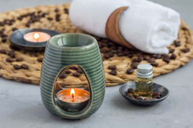 Aroma lambası, örülmüş hasırın üstüne kahve yağı, kaplıca arka planı, yatay