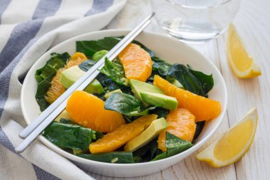 Sağlıklı ıspanak, avokado ve zencefil sirke soslu portakal salatası, yatay.