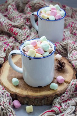 Emaye bardakta lokum kaplı ev yapımı sıcak çikolata, arka planda sıcak eşarp, dikey...