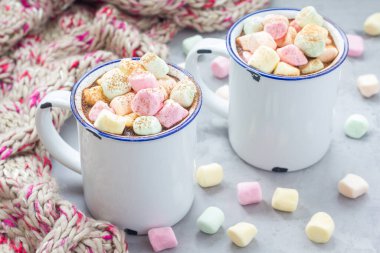 Ev yapımı sıcak çikolata, üzerinde lokum, diş minesi bardağı, arka planda sıcak eşarp, yatay.