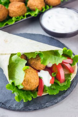 Sebze ve soslu nohut köftesi, rulo sandviç hazırlama, dikey.