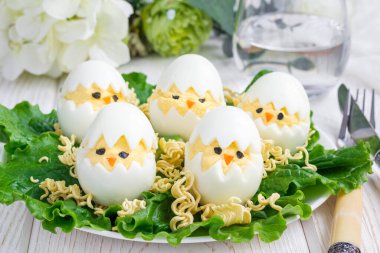 Yuvada küçük bir tavuk, salata ile servis edilmiş baharatlı yumurta ve beyaz tabakta kuru ramen, yatay.