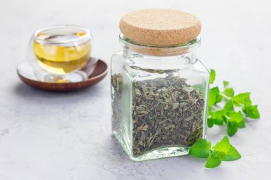 Kavanozda kurutulmuş nane çayı. Arka planda çay, yatay.