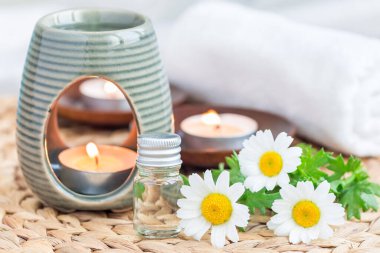 Papatya yağı, örülmüş hasırın üzerindeki camda, spa arka planında, yatay.