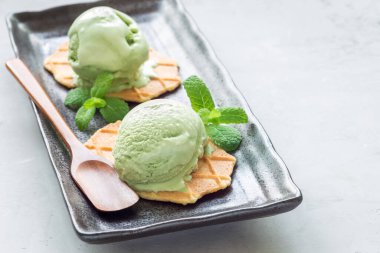 Siyah tabakta waffle ile servis edilen kibrit yeşili çay topları, yatay, kopyalama alanı