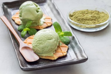 Siyah tabakta waffle ile servis edilen kibrit yeşili çay topları, yatay, kopyalama alanı