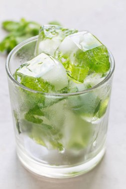 İçinde nane yaprakları olan ev yapımı buz küpleri. Arka planda taze nane şekeri. Limonata ve kokteyl için buz.