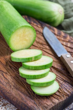 Sebze yemeği hazırlıyorum. Kabak ve kabak tahta bir kesme tahtasında dikey dilimler.