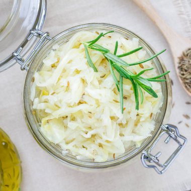 Cam kavanozda kimyon bulunan ev yapımı lahana turşusu, üst görünüm, kare format.