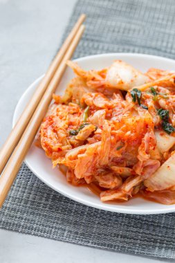 Kimçi lahanası. Beyaz tabakta Kore aperatifi, dikey.