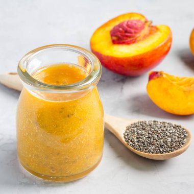 Nektarinli meyve suyu, portakal suyu, cam kavanozda chia tohumu ve bal, kare formatta.