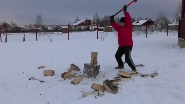 Teenboy hugga veden på byn gården — Stockvideo