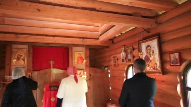 ABKHAZIA, KAMAN - OCTOBER 28, 2016: The parishioners came into the wooden church of holy martyr Basiliscus — Stock Video