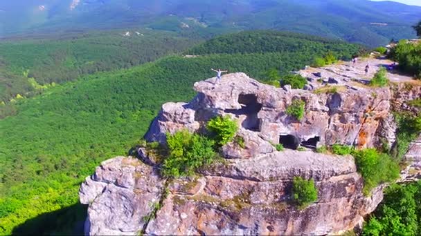 Luchtfoto op man staan op de grote rots — Stockvideo