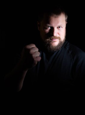 Katı sakallı orta yaşlı adam yumruk sallıyor