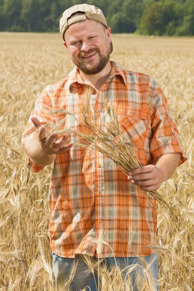 Rolnik w cap stojący w polu — Zdjęcie stockowe
