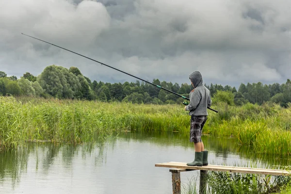 Adolescente chico pesca en madera muelle —  Fotos de Stock