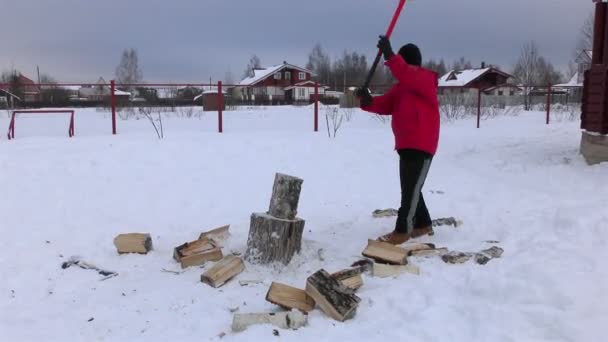 Adolescent couper le bois à la cour du village — Video