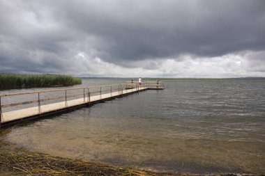 Ahşap iskele ve balıkçılar ile dramatik peyzaj