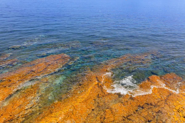 Textura natural colorida com mar azul e rochas amarelas — Fotografia de Stock