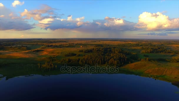 Drone flygning över sjön och fält i omgivningen av Izbork — Stockvideo