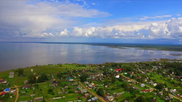 Вид с воздуха на населенный пункт на берегу озера — стоковое видео