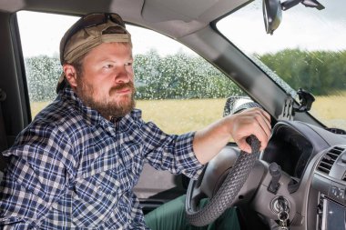 Bir araba kulübede oturan sakallı adam