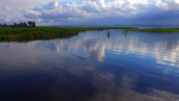 Vlucht boven het wateroppervlak met reflecties van wolken — Stockvideo