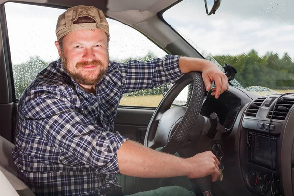 Бородатый мужчина, сидящий в кабине автомобиля — стоковое фото