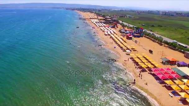 Vuelo en avión no tripulado sobre la playa de arena de Crimea con sombrillas — Vídeo de stock