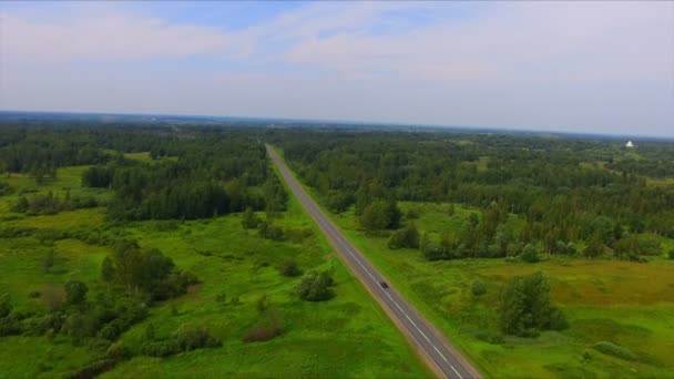 Vuelo en avión no tripulado sobre la carretera entre los bosques verdes — Vídeo de stock
