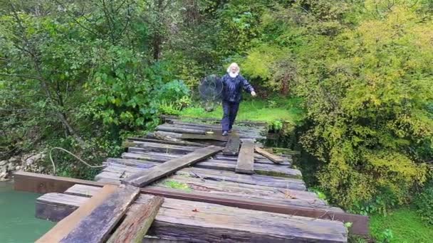 Eski ahşap köprü ile yürüyen adam — Stok video