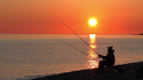 美丽的景色与杆坐在海滩上的渔夫剪影 — 图库视频影像
