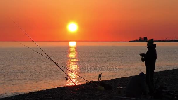 Mooie scène met visser silhouet met rod zittend op zee strand — Stockvideo