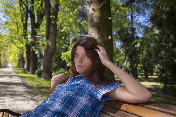 Mooie jonge vrouw in casual kleding, zittend op de Bank — Stockfoto