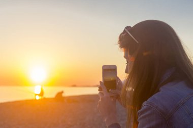 Onun mobil kullanarak sahilde genç güzel kadın