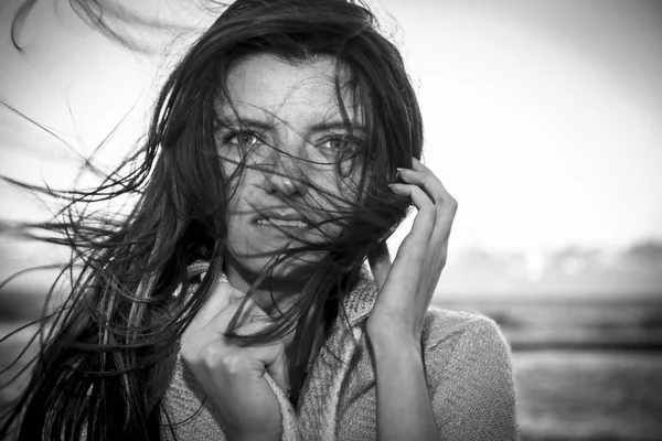 Jonge mooie lange haren vrouw op winderige kust — Stockfoto