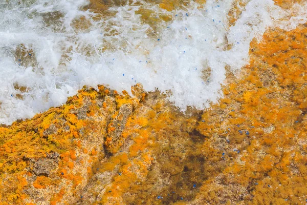 Textura natural colorida com ondas do mar e rochas amarelas — Fotografia de Stock