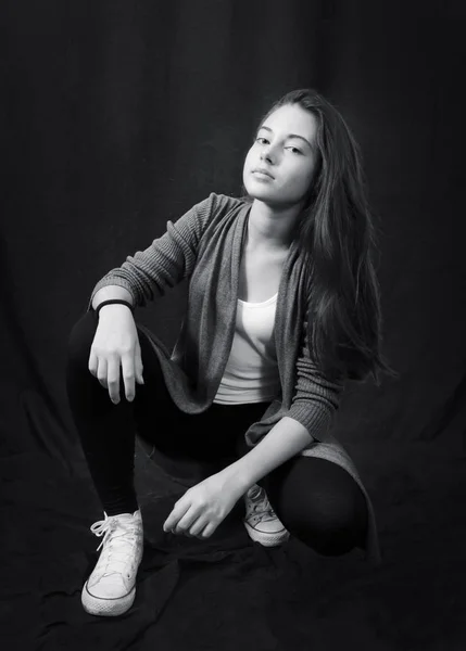 Zwart-wit portret van jong mooi meisje zittend — Stockfoto