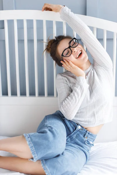 skeptic young woman  happy at home. beautiful young woman in glasses laying in bed. glasses close up.resting at home. reading in bed concept. home alone. comfortable home concept. isolation. I stay at home. freelancer. surprised woman