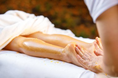 Ayak masajı. Doktor ayaklara, topuklara ve ayak parmaklarına masaj yapar. anti selülit konsepti. Bal ve portakallı spa salonundaki ayak masajını kapat.