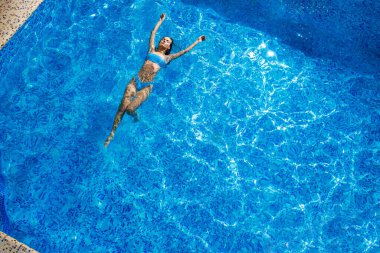 Havuzda yüzen kız manzarası. Havuzda mavi bikinili mükemmel ince vücutlu güzel bir kız. Tatil köyü konsepti. Yaz zamanı. Havuz kapalı. Otel servisi kavramı