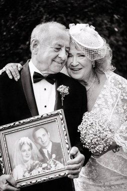 Büyükanne ve büyükbaba 50 yıl sonra düğün fotoğraflarını tutuyorlar. Yaşlı çift düğünü. Altın evlilik yıldönümü kutlaması. Büyükanne ve büyükbaba evleniyor. 50 yıldır birlikteyiz. Yaşlı çift evli.
