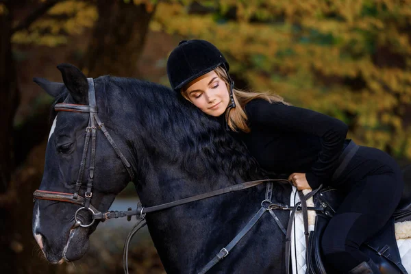 美しい若い女の子が山の中で馬に乗る 馬術競技だ 女のジョッキー ブロンドの女の子が馬に乗って森の中で — ストック写真