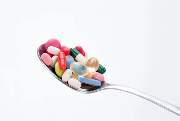 Vele kleurrijke pillen en tabletten in lepel — Stockfoto