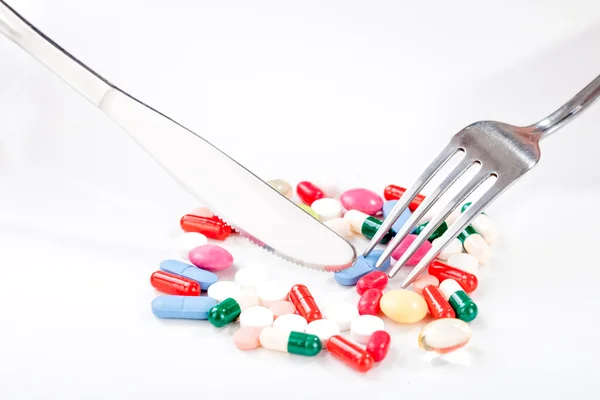 Droger, läkemedel på en maträtt med gaffel, sked — Stockfoto